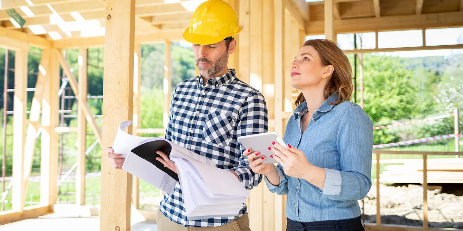 An owner-builder reviewing construction plans on-site, ensuring project alignment and quality
